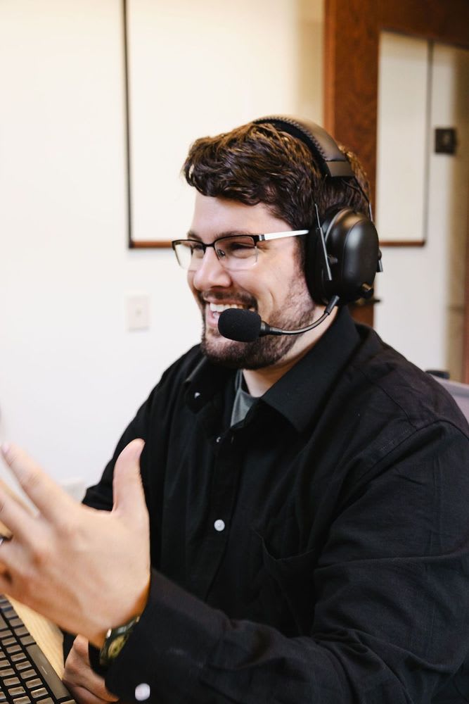 A man with a headset on, appearing attentive and immersed in a virtual meeting or call.