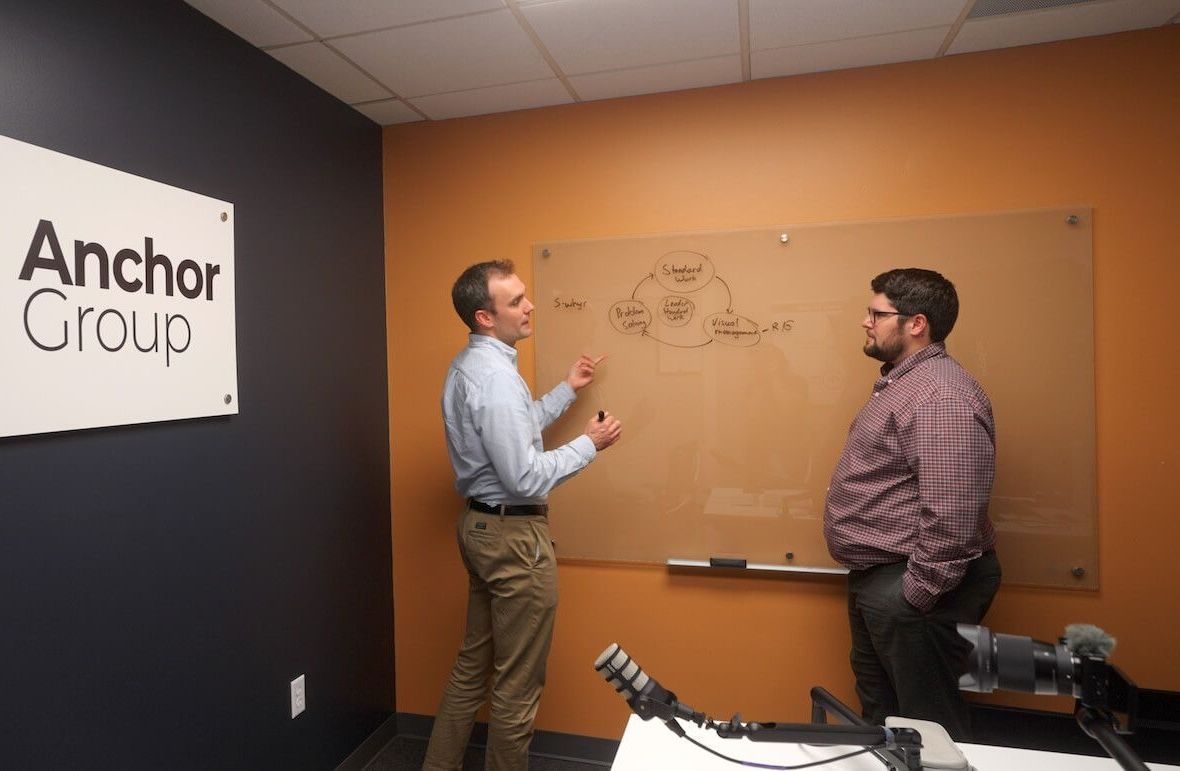 Anchor Group Employees Standing Solving Problems
