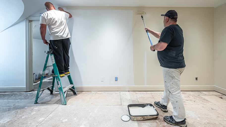 Men painting white wall
