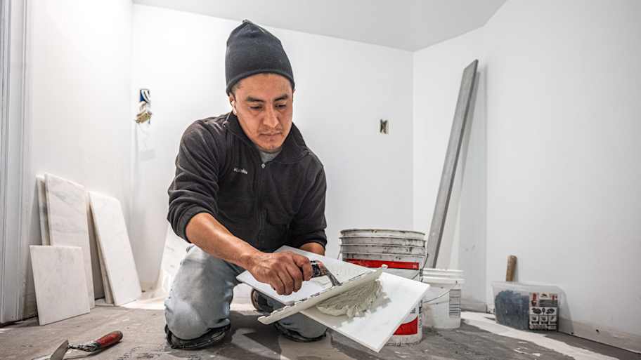 Man installing tile floor.