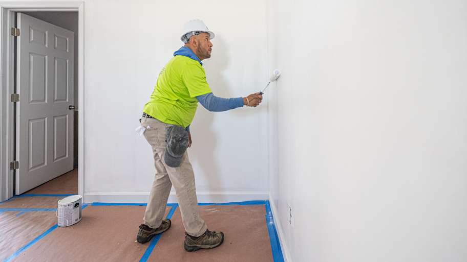 Painter painting the wall with paint roller