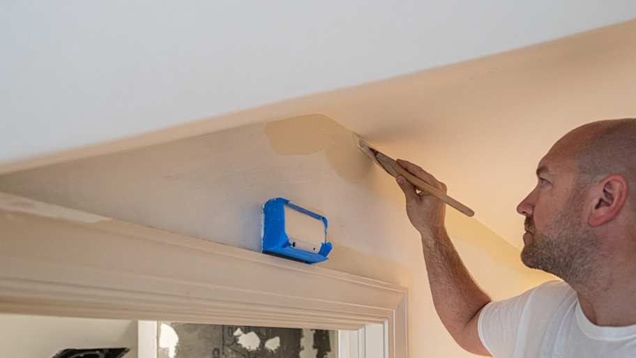Painter painting the wall with brush