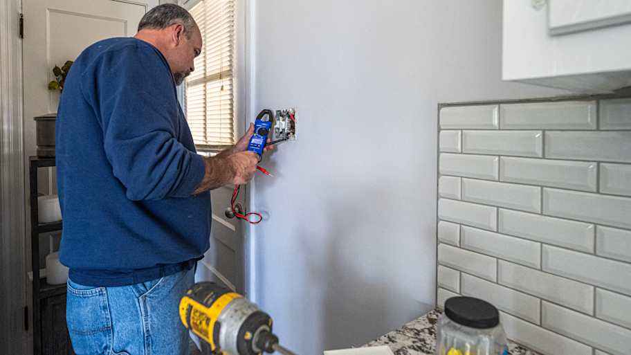 Electrician testing power to an outlet in the kitchen.