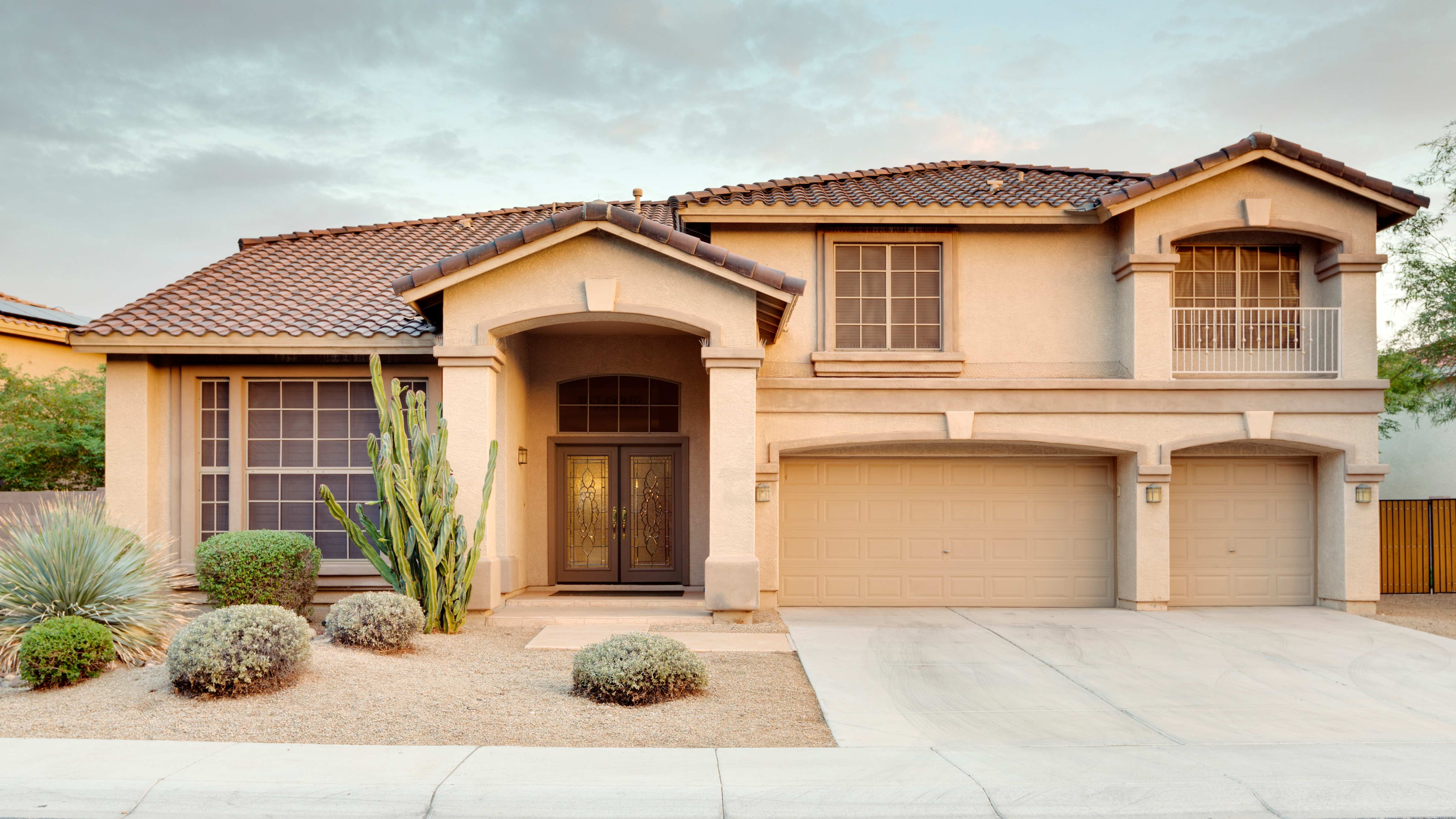 Large home exterior with stucco siding and tile roof