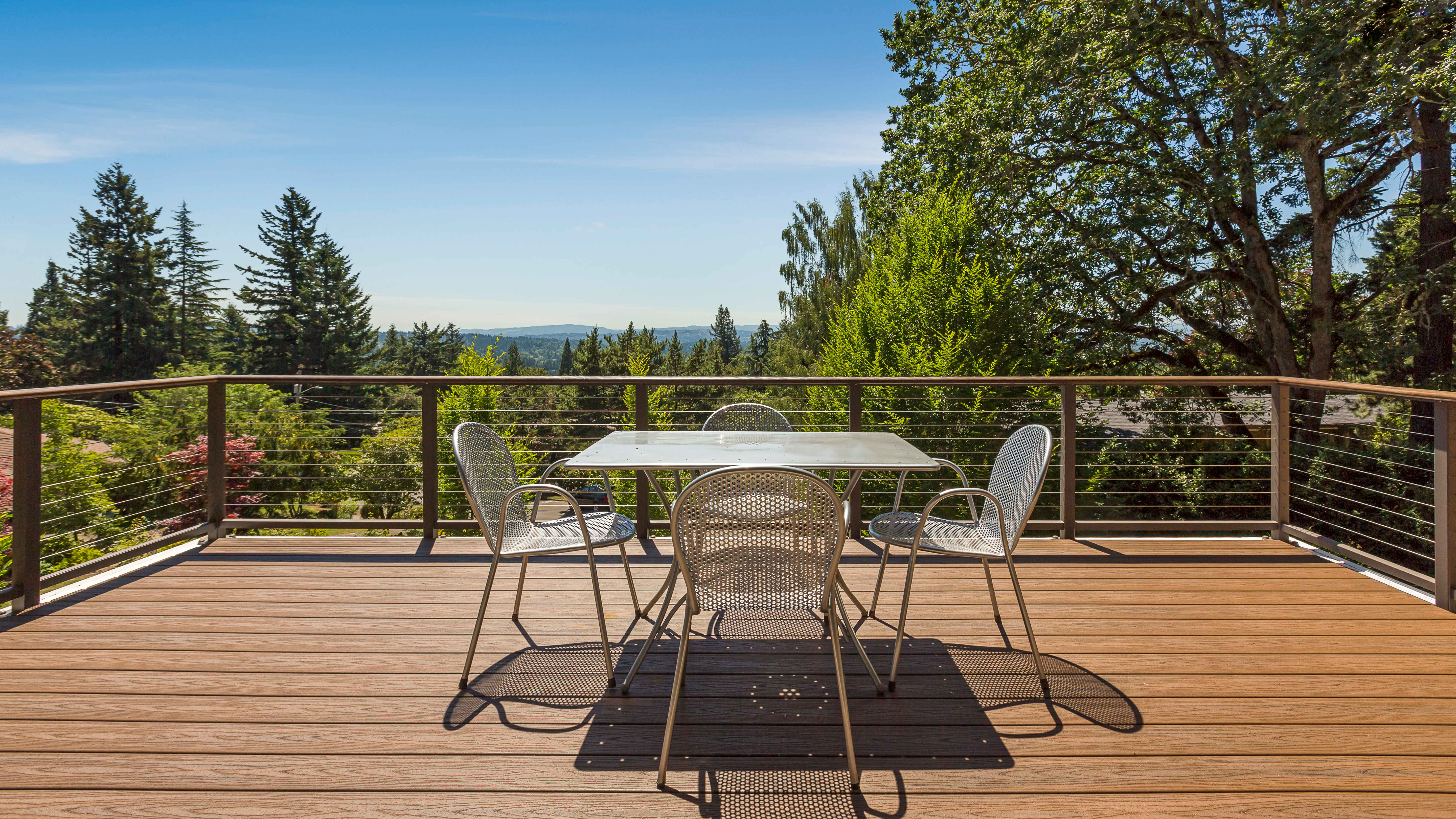 Wooden deck with cable railing and outdoor furniture