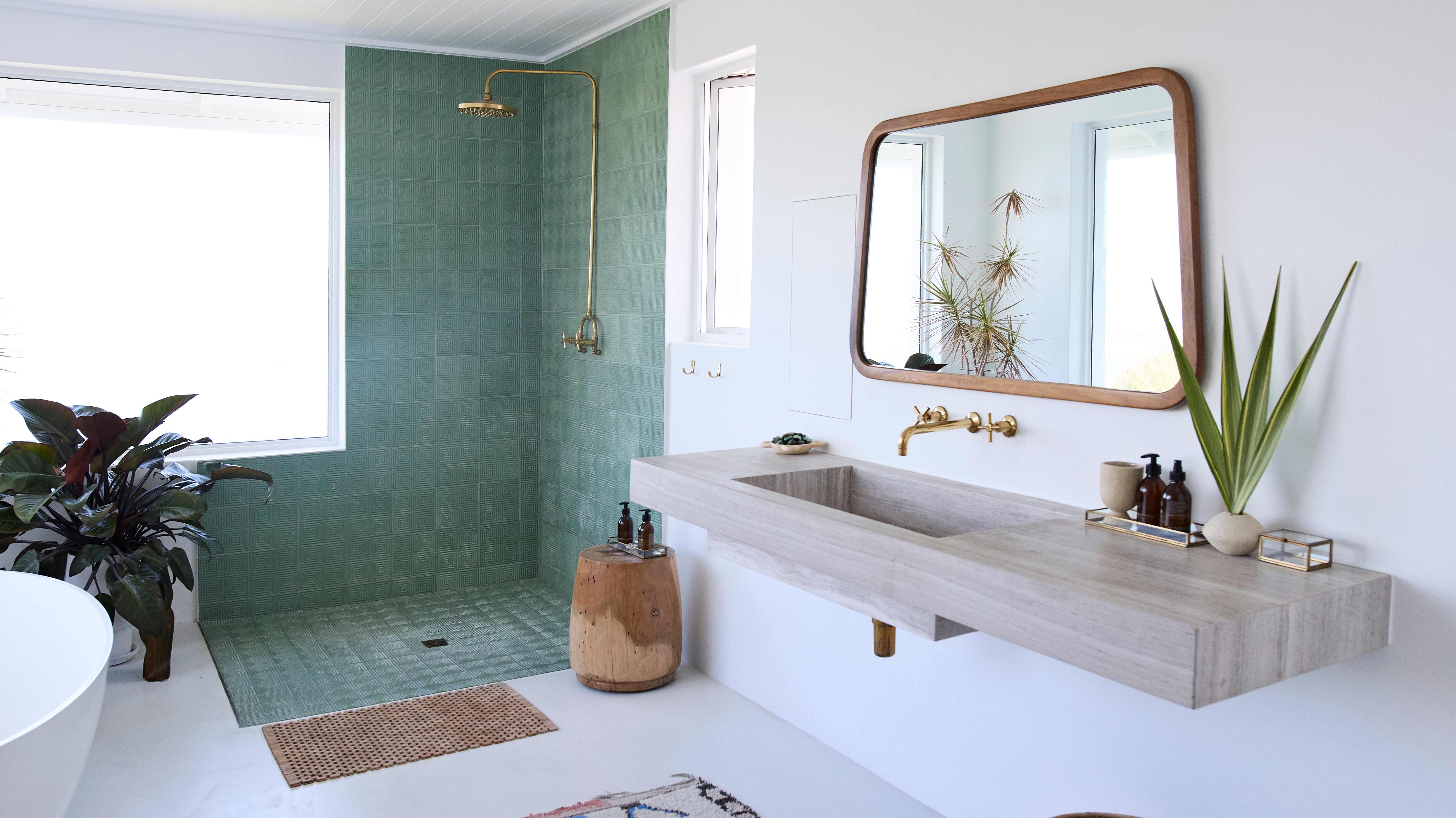 Doorless walk-in shower with green tiles on the floor and walls