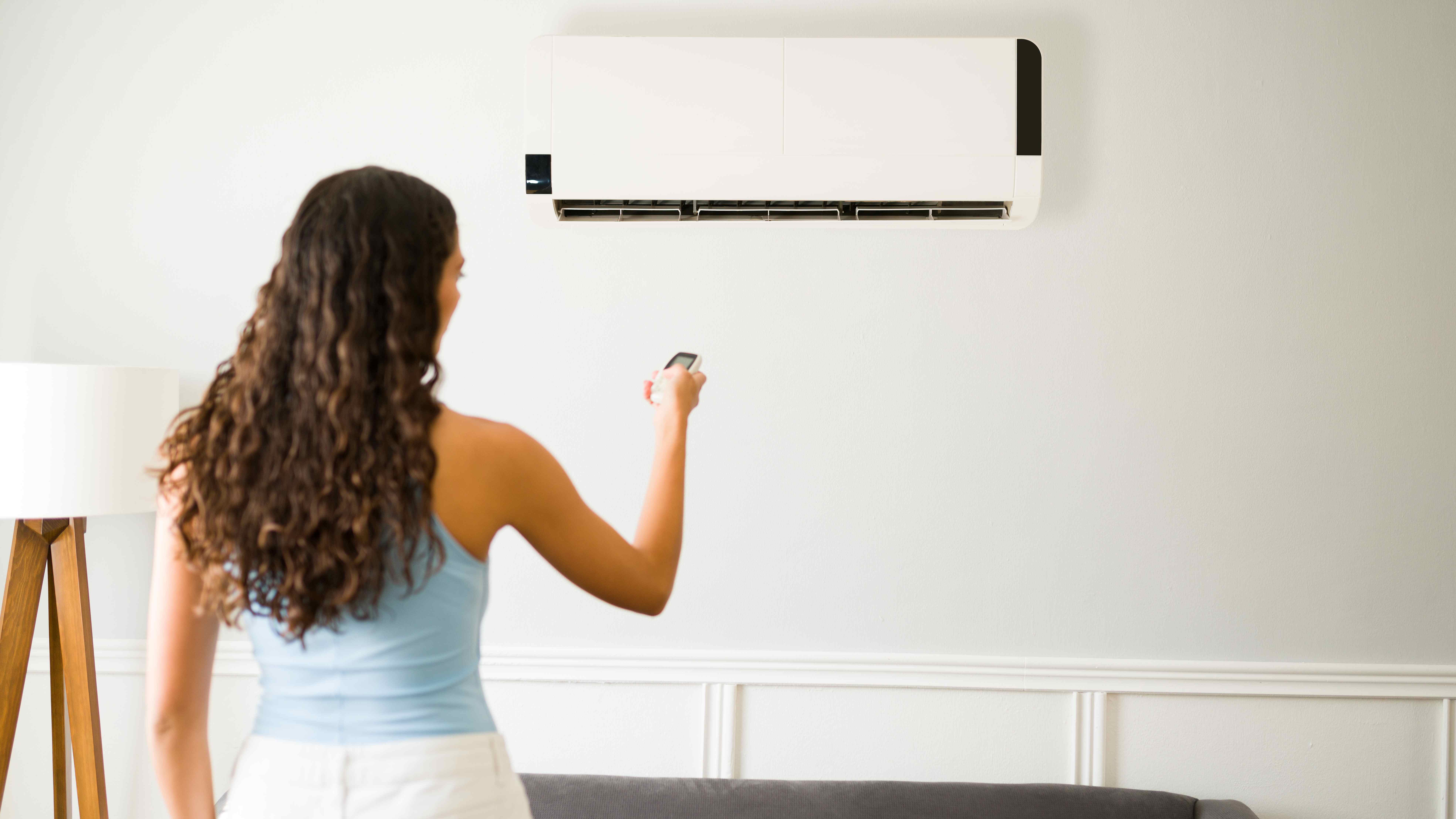 Woman adjusting temperature on a mini-split system