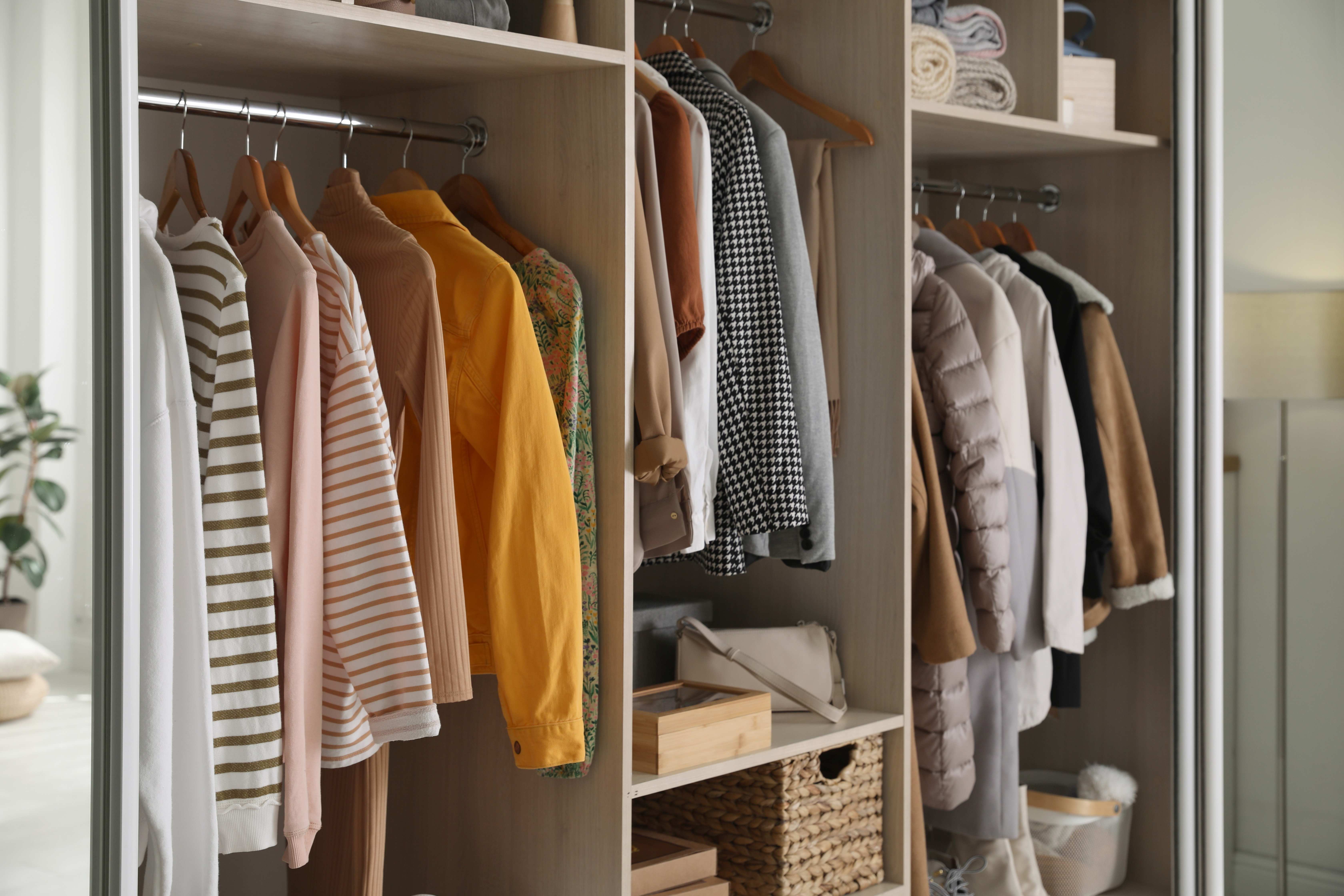 A neatly organized wardrobe closet filled with stylish clothes, accessories, and home items, showcasing efficient closet storage solutions.