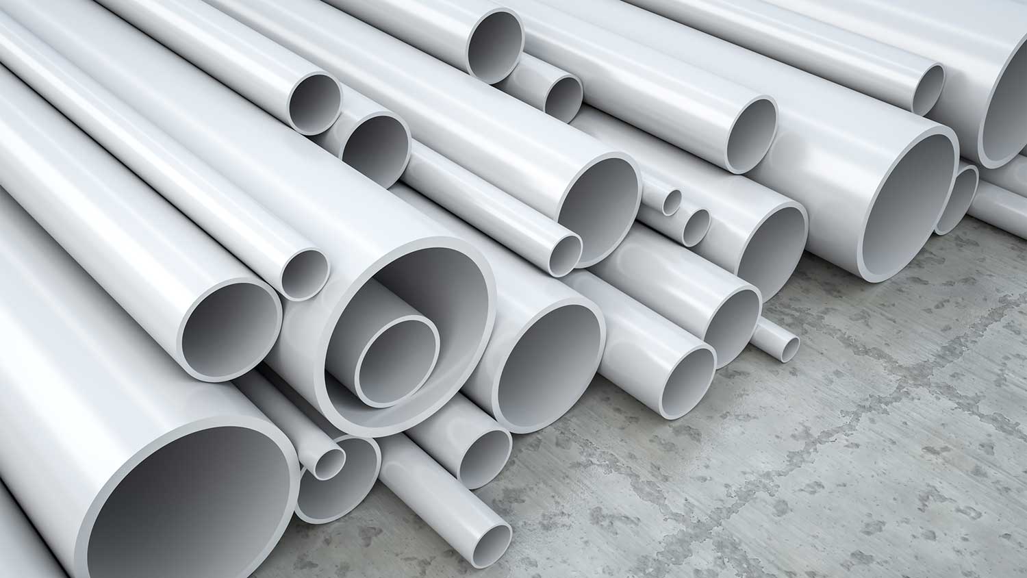 Pile of different sized PVC pipes stalked on the floor