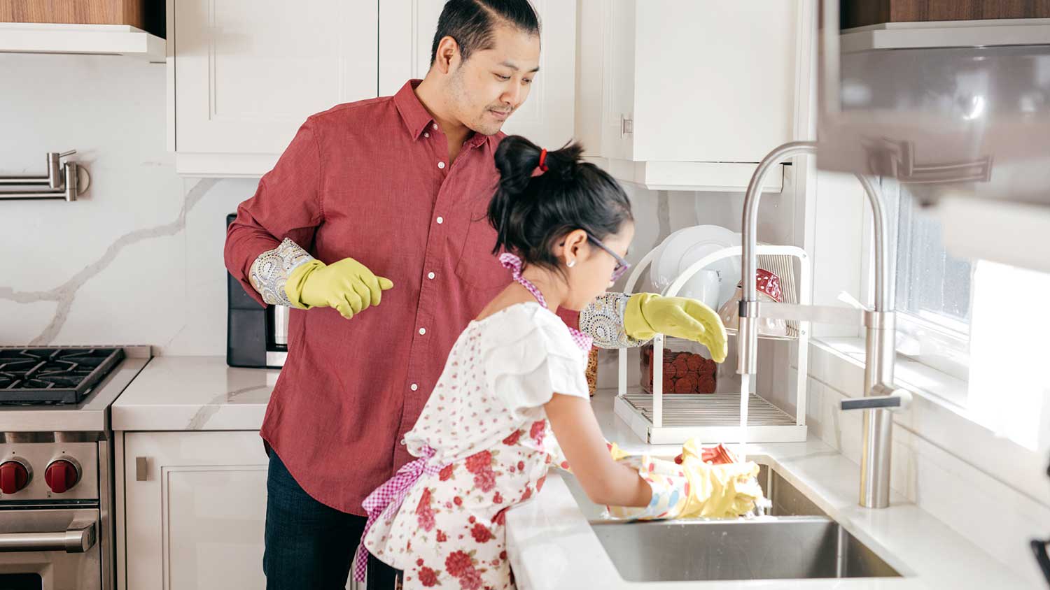 Daughter helping washing dishes in the kitchen