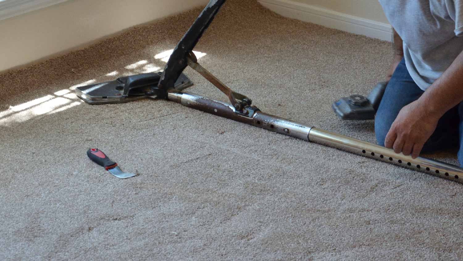A professional stretching properly a carpet