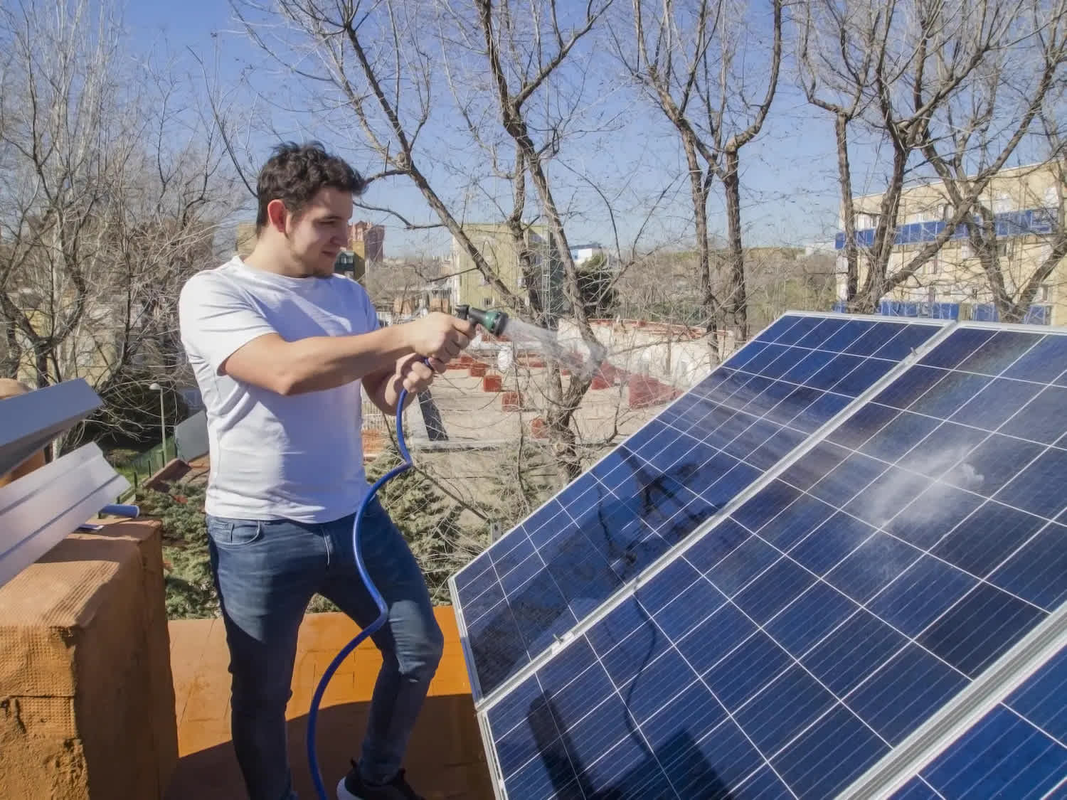 Man hosing down solar panels