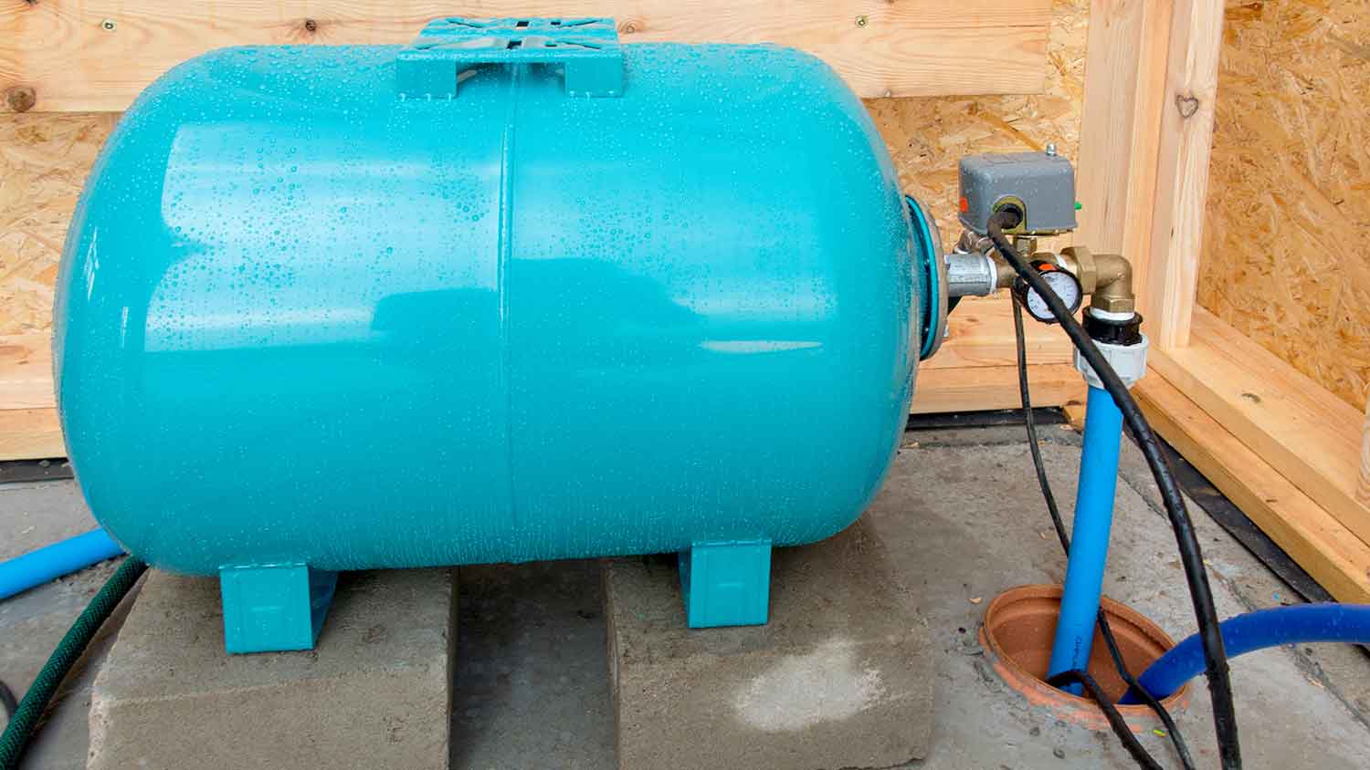 Water well pressure tank sitting on concrete slabs