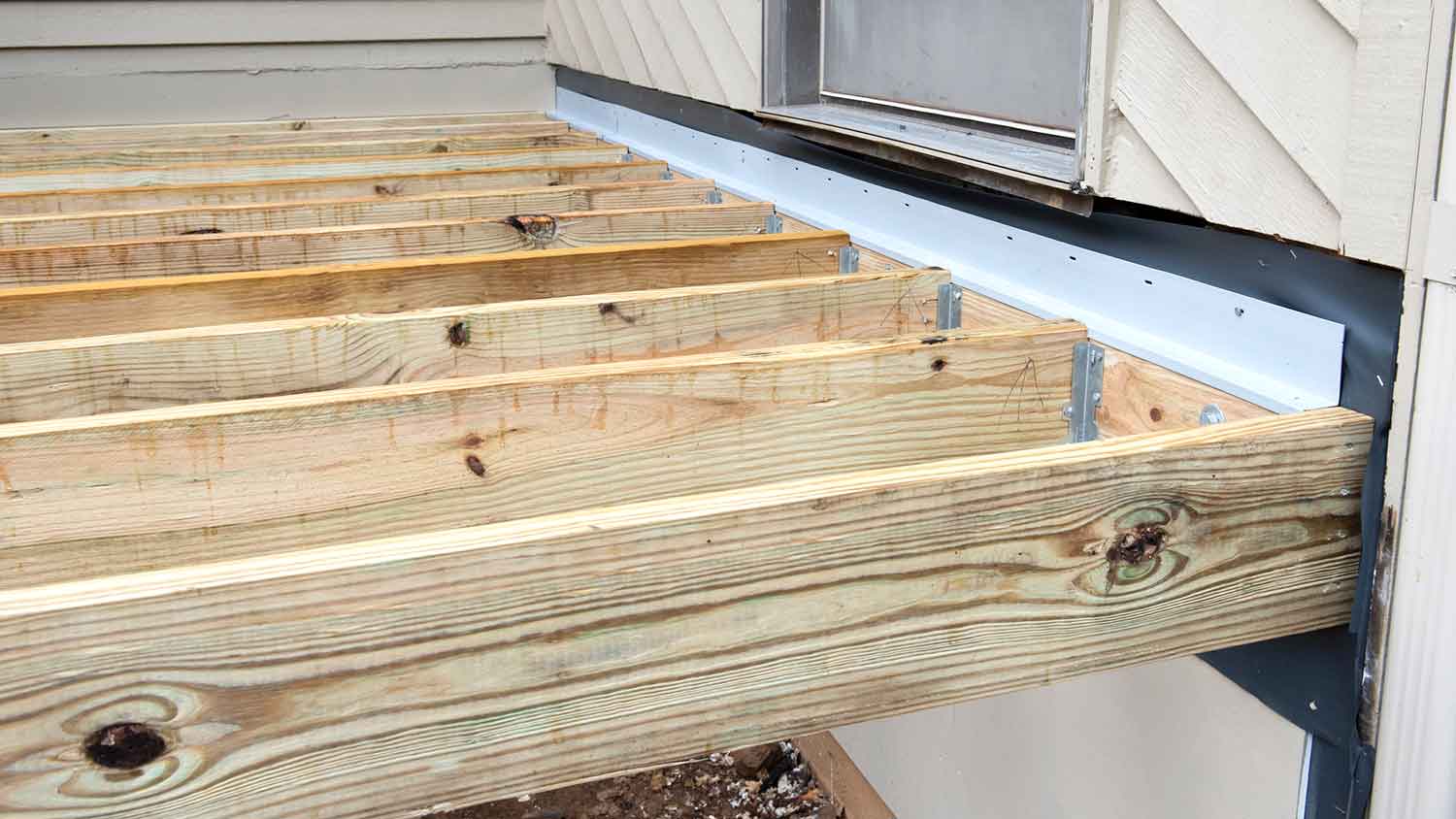 Deck flashing attached to ledger board