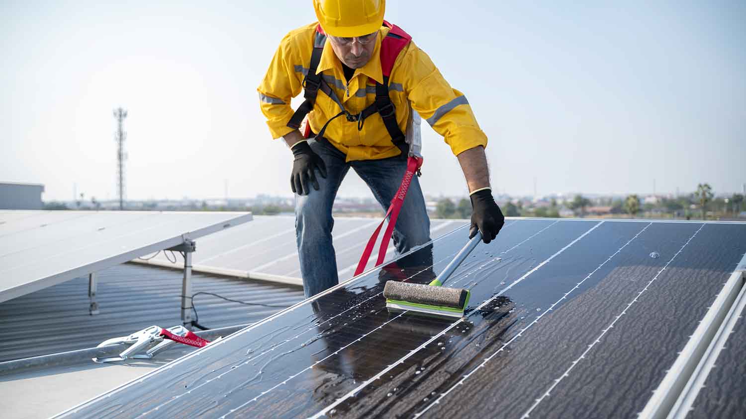 Professional cleaning solar panels on the roof