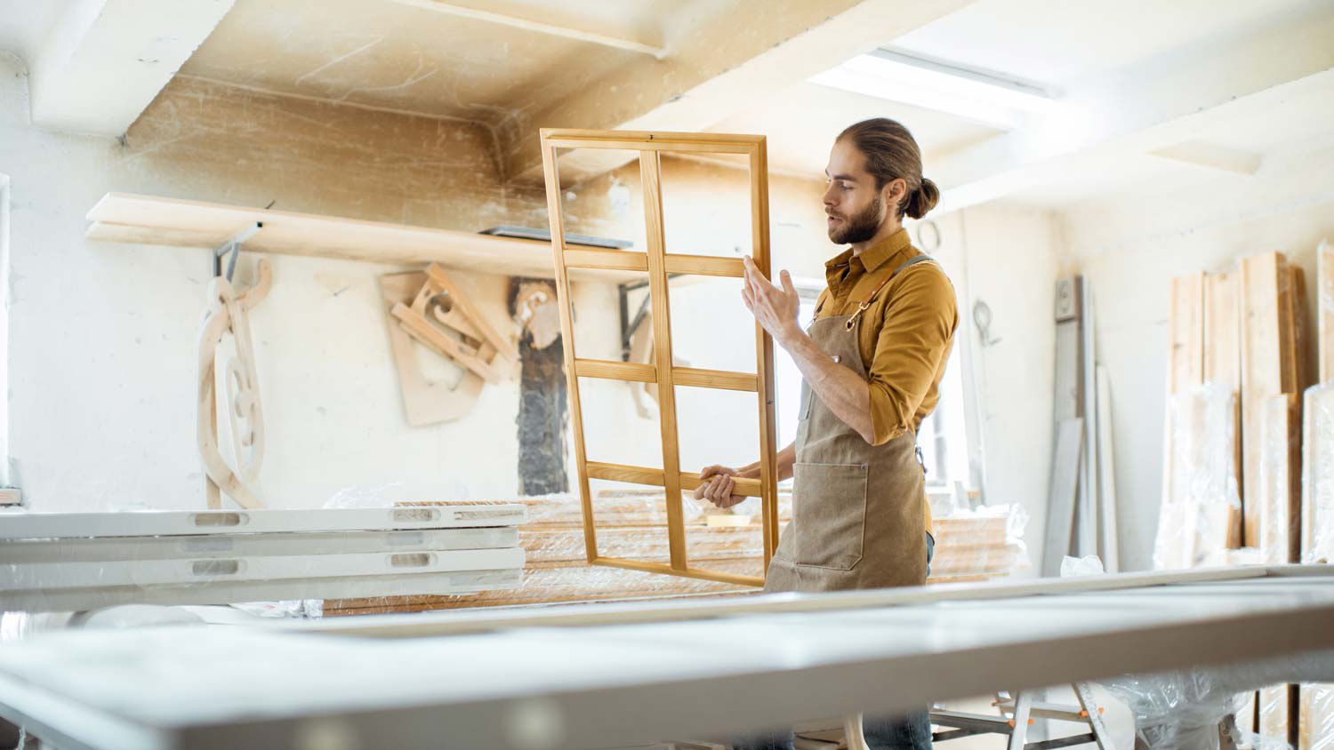A man inspecting a wooden window frame