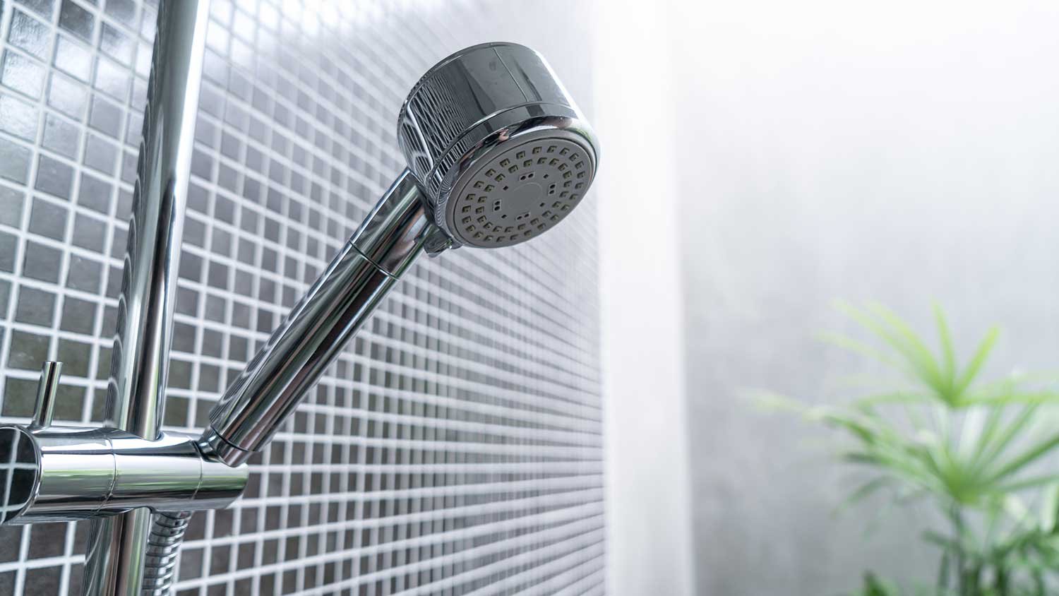 Adjustable hand-held shower head installed in the shower