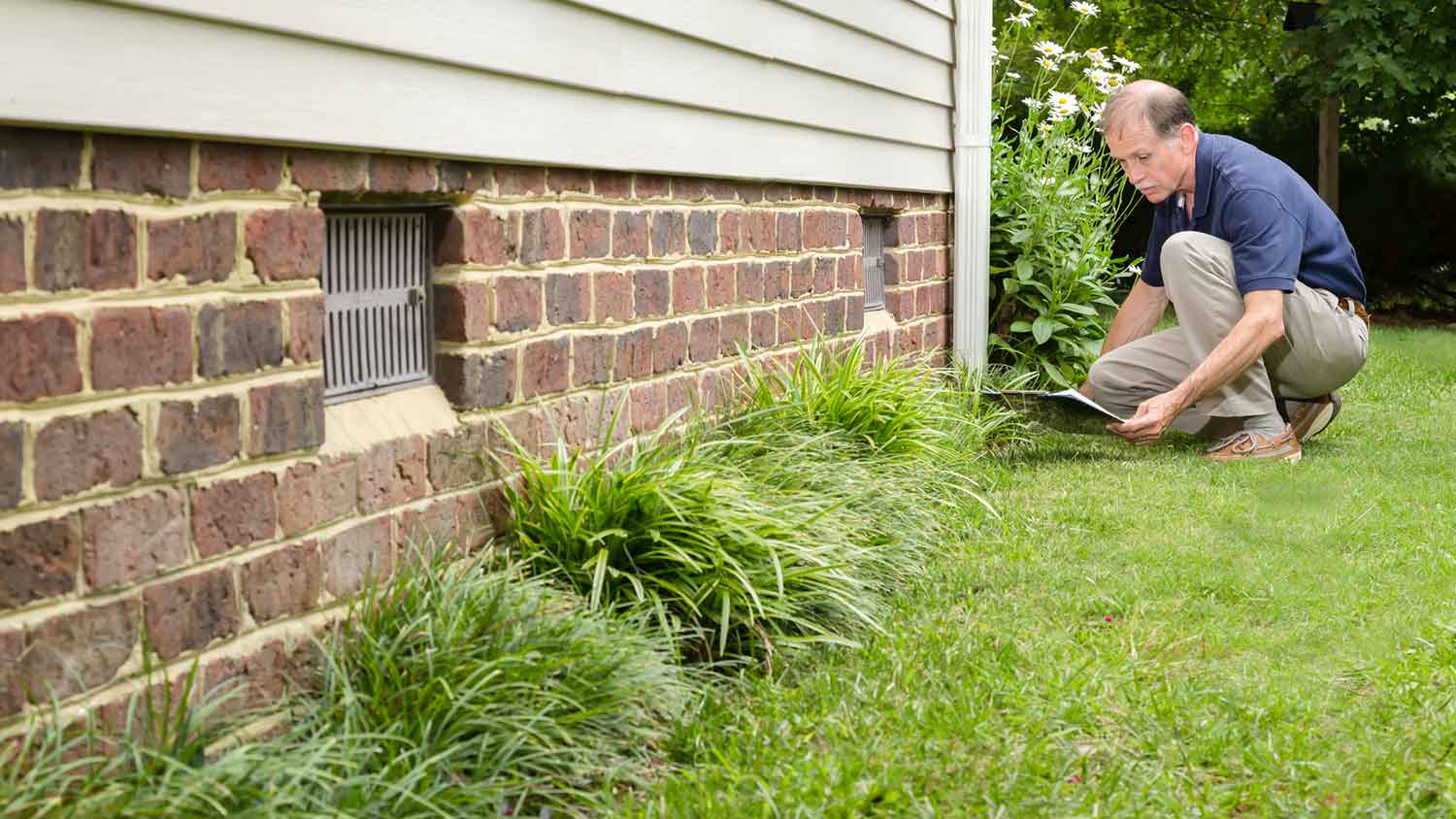 Inspector assessing damage of house foundation
