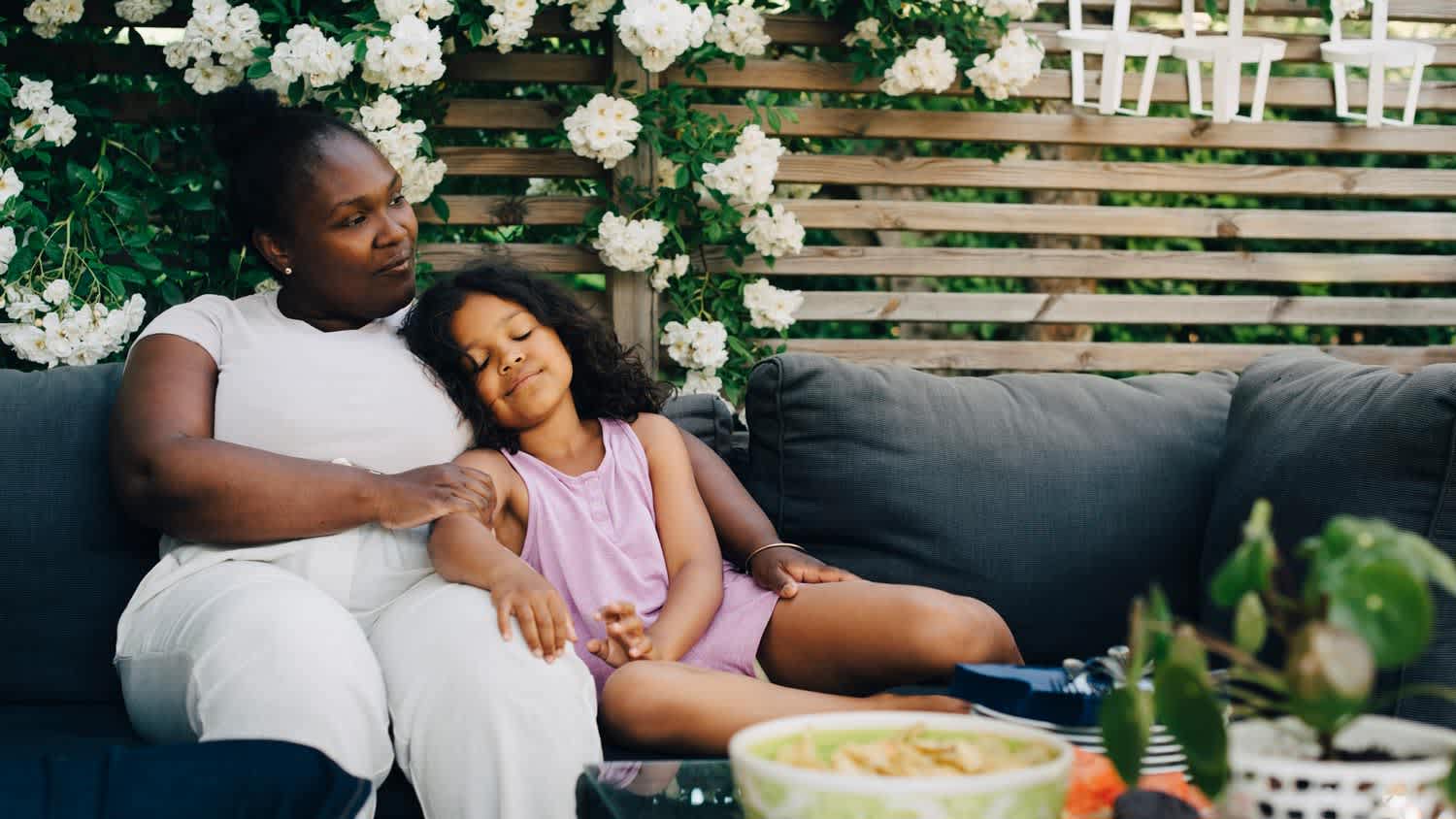 A daughter resting by her mother in a backyard garden