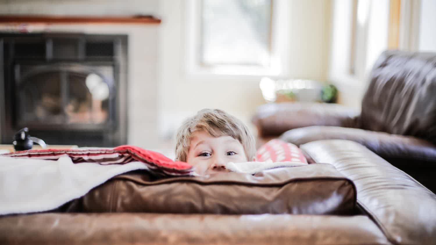 A young boy peeks above the cushions
