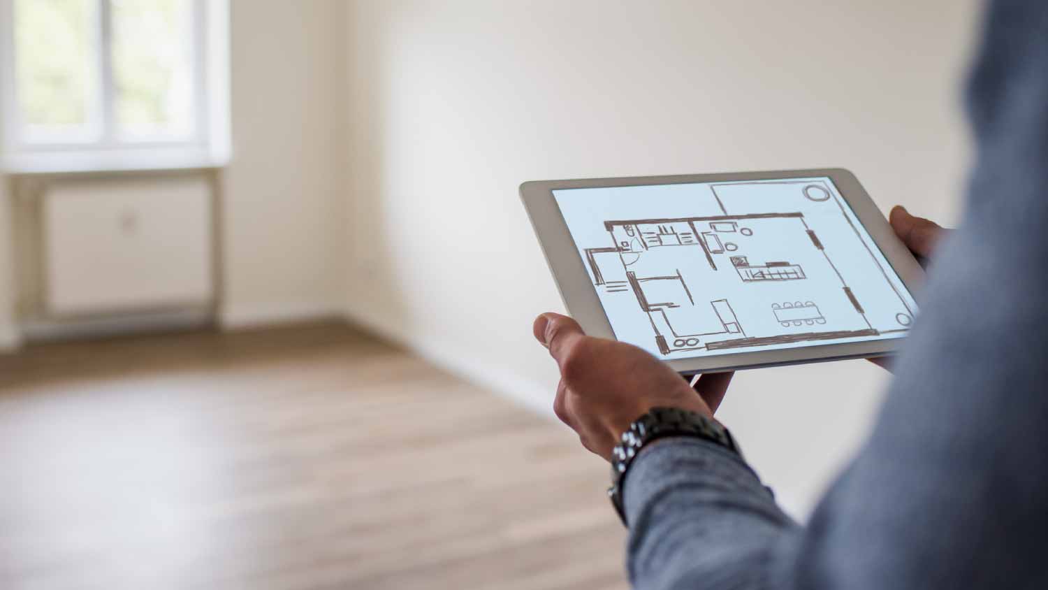 Man holding tablet with floor plan