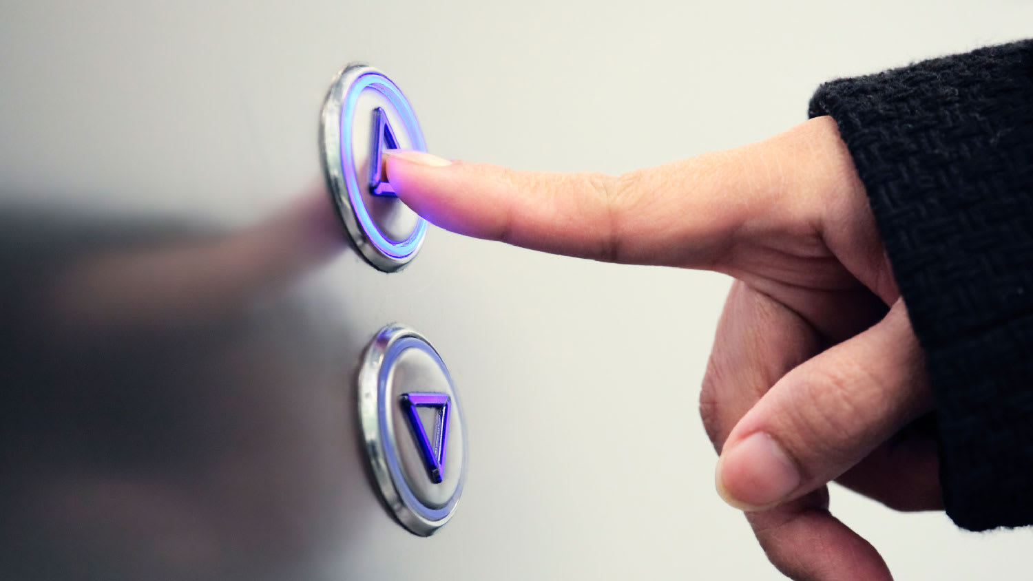 A woman pressing the elevator button