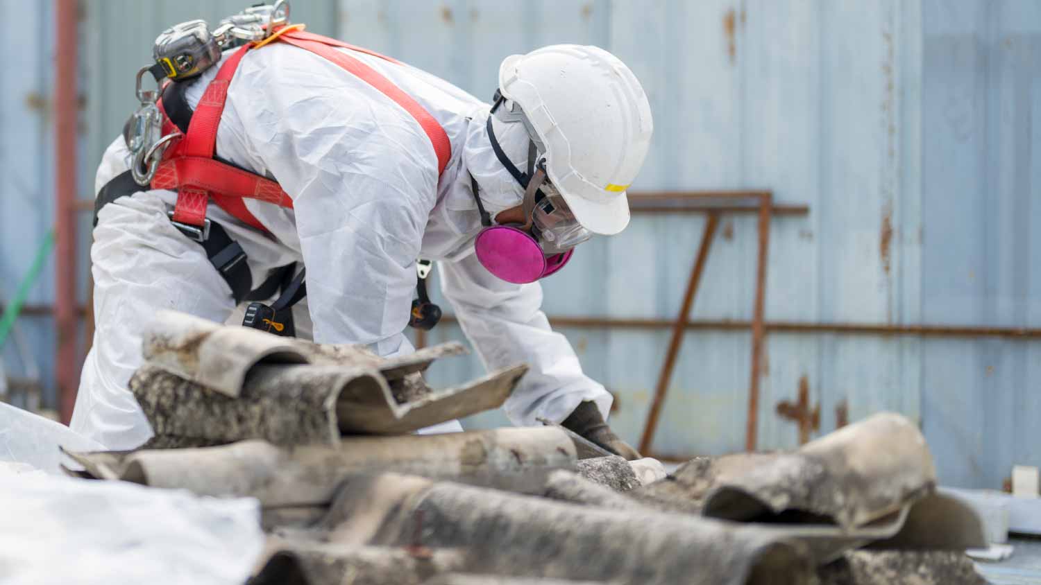 Worker working with the asbestos roof tiles