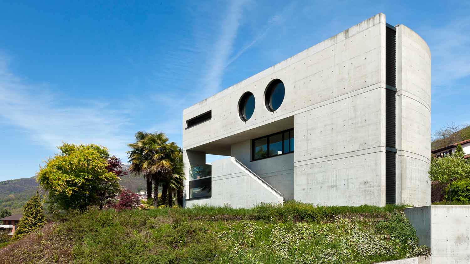 Brutalist style house exterior surrounded by hills