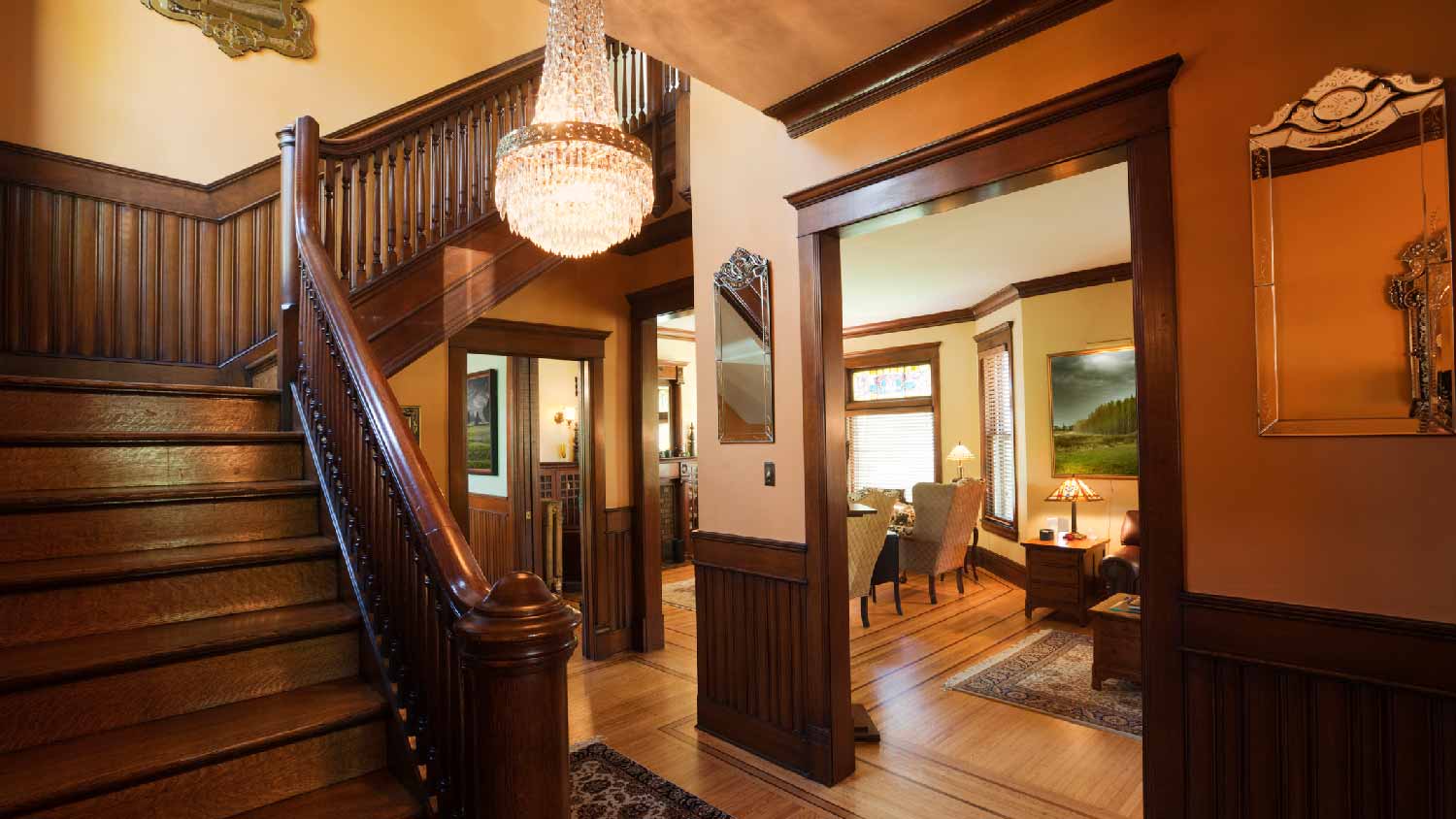 The interior of a Victorian house with a grand wooden staircase