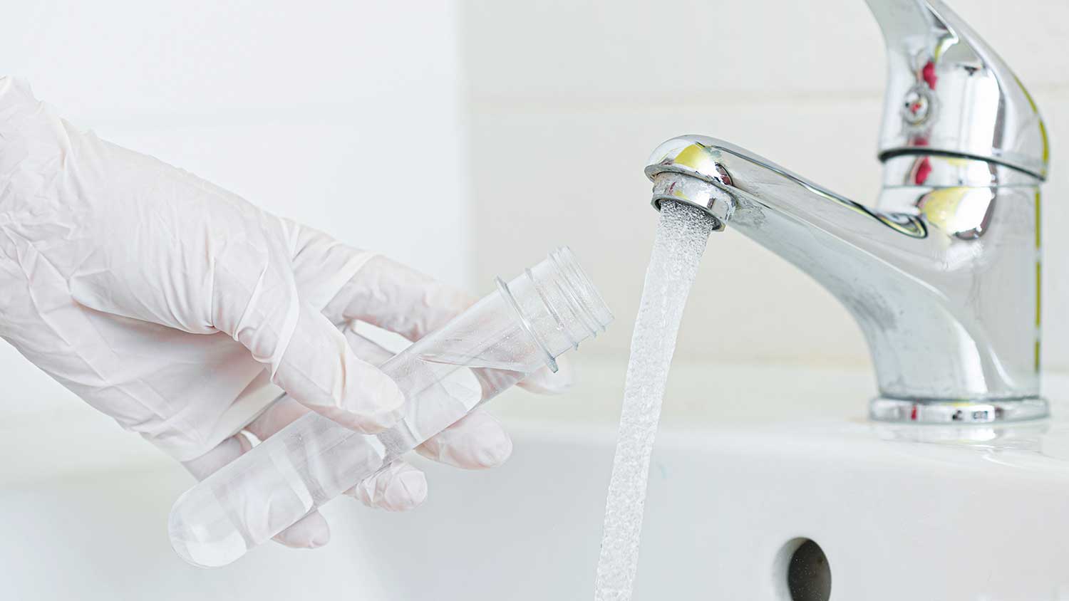 Person collecting water sample from the faucet