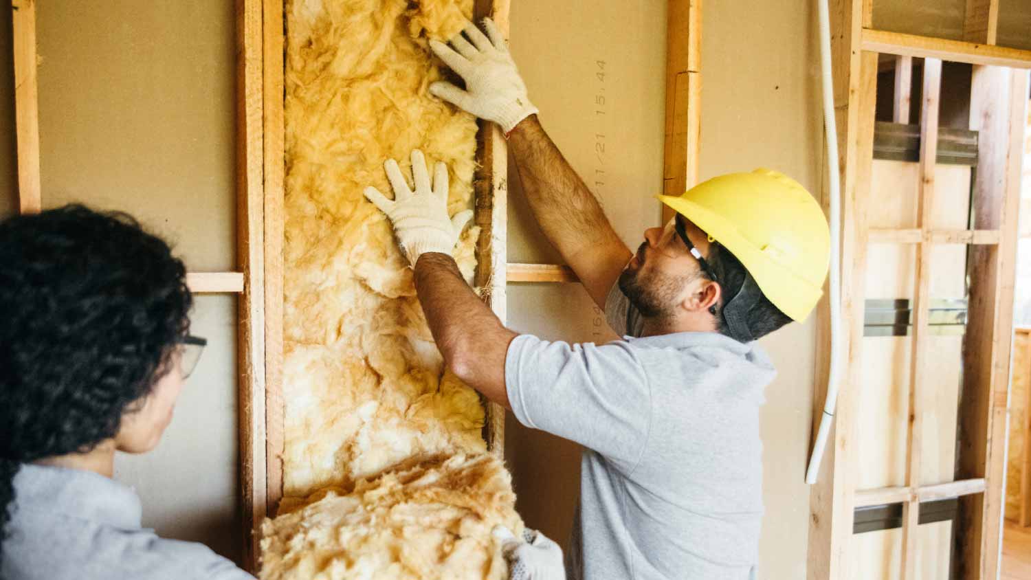 Construction workers fitting insulation
