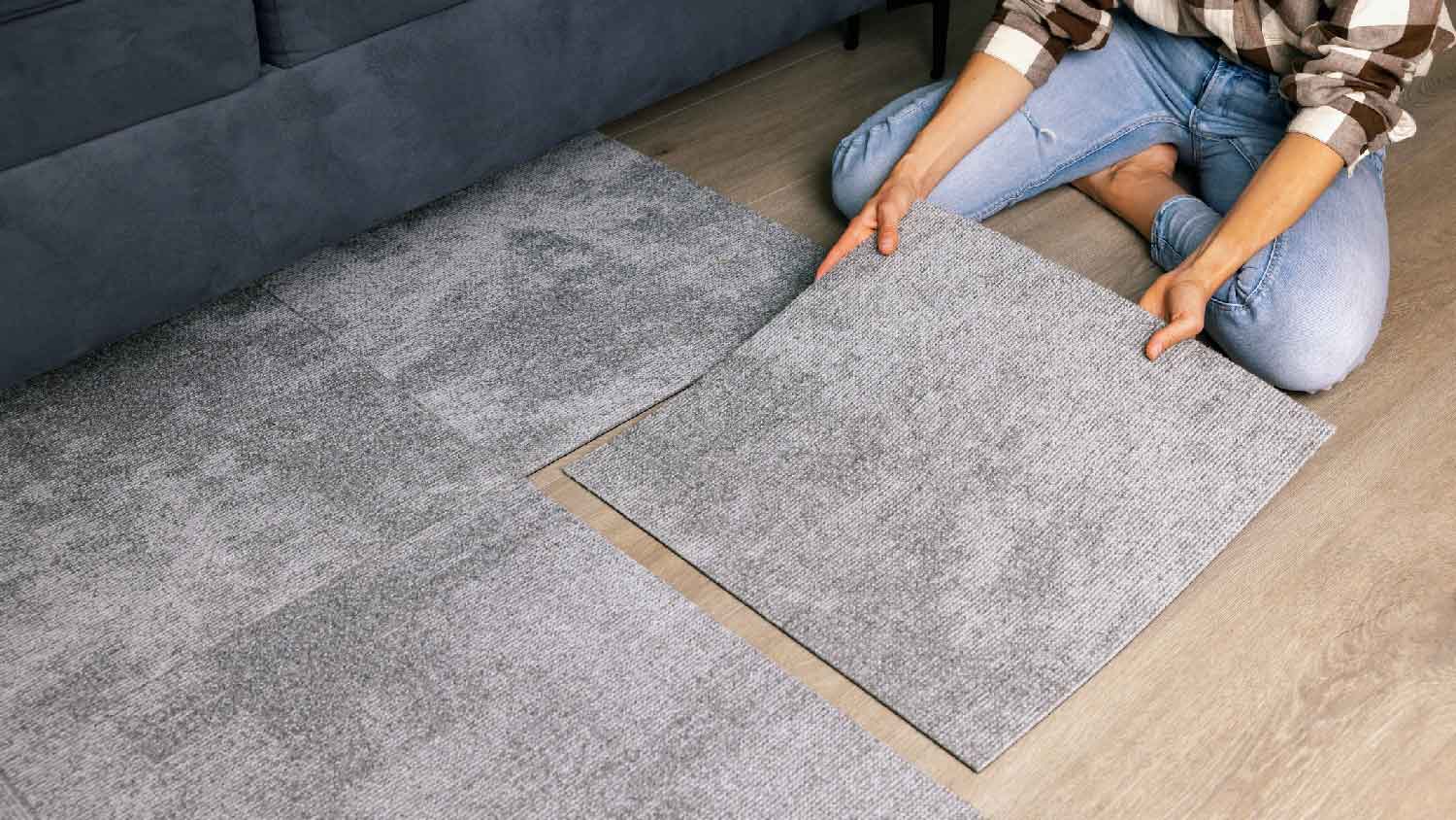 A woman laying carpet tiles