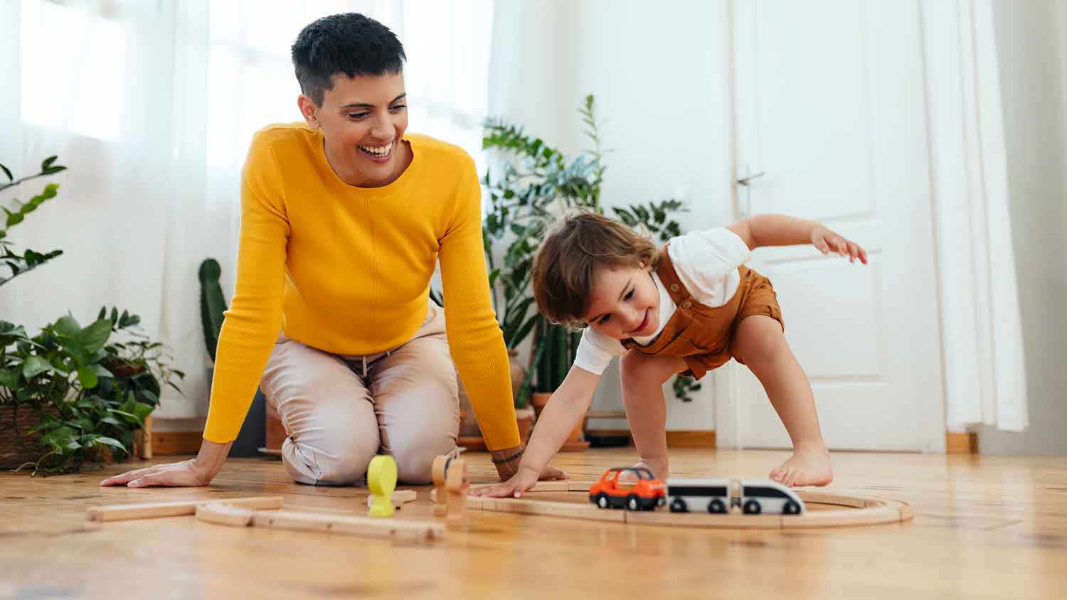 Mother and child sitting on the floor and playing with toys