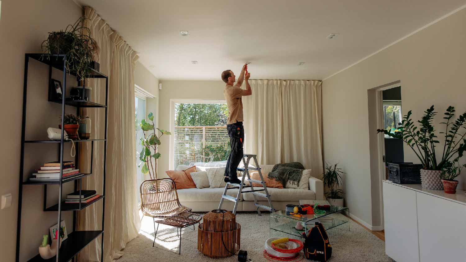 A man installing a light fixture on the ceiling