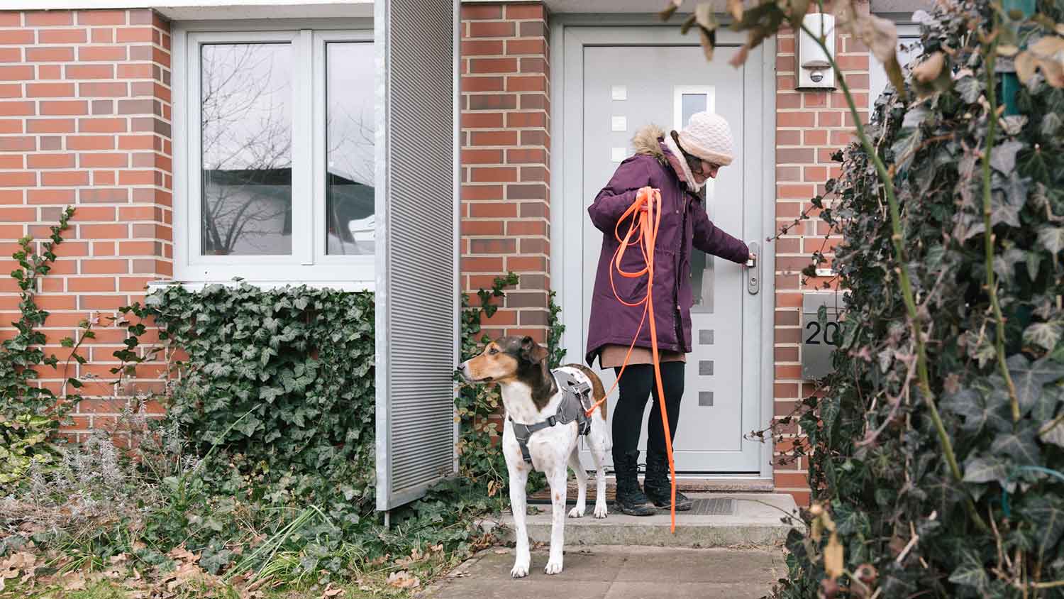 Woman locking front door before going for a walk with her dog