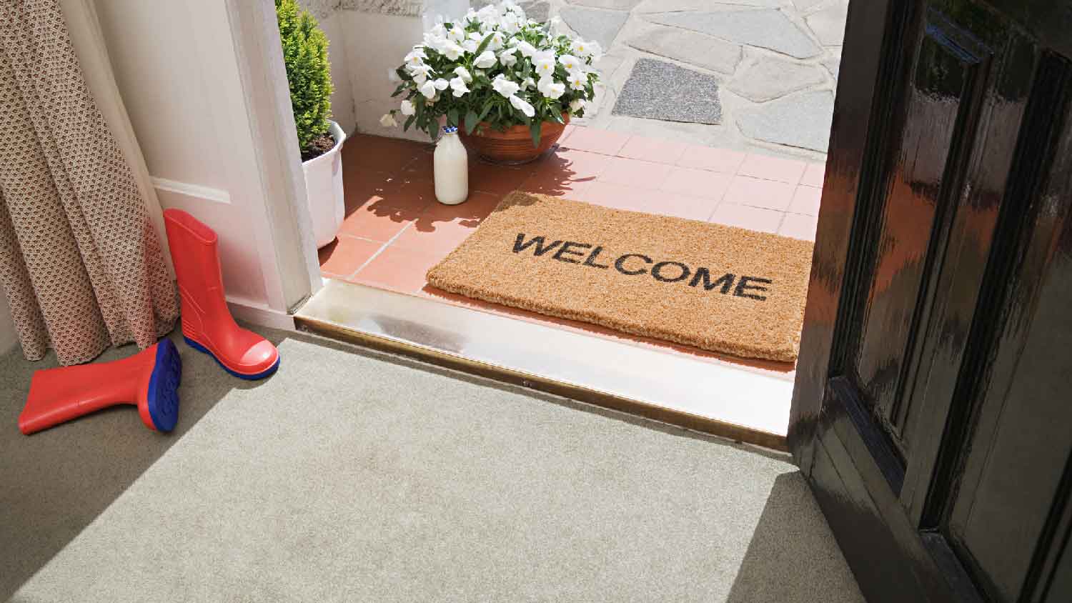 A door threshold in front of welcome doormat