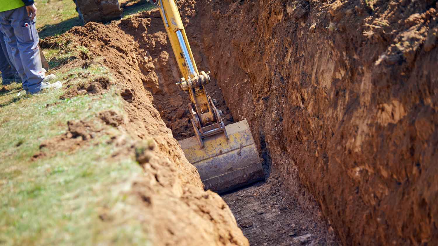 excavator digs into ground