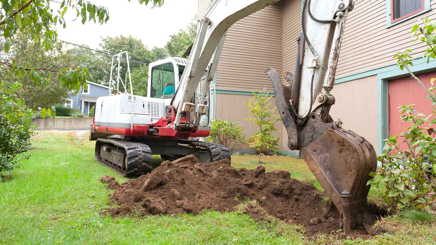 Professional using excavator to dig out space for a swimming pool
