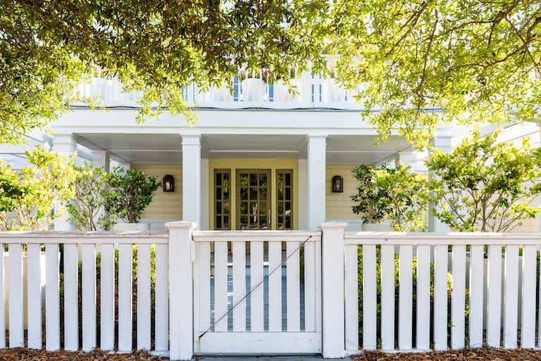 white wooden gate in front of white two-story house