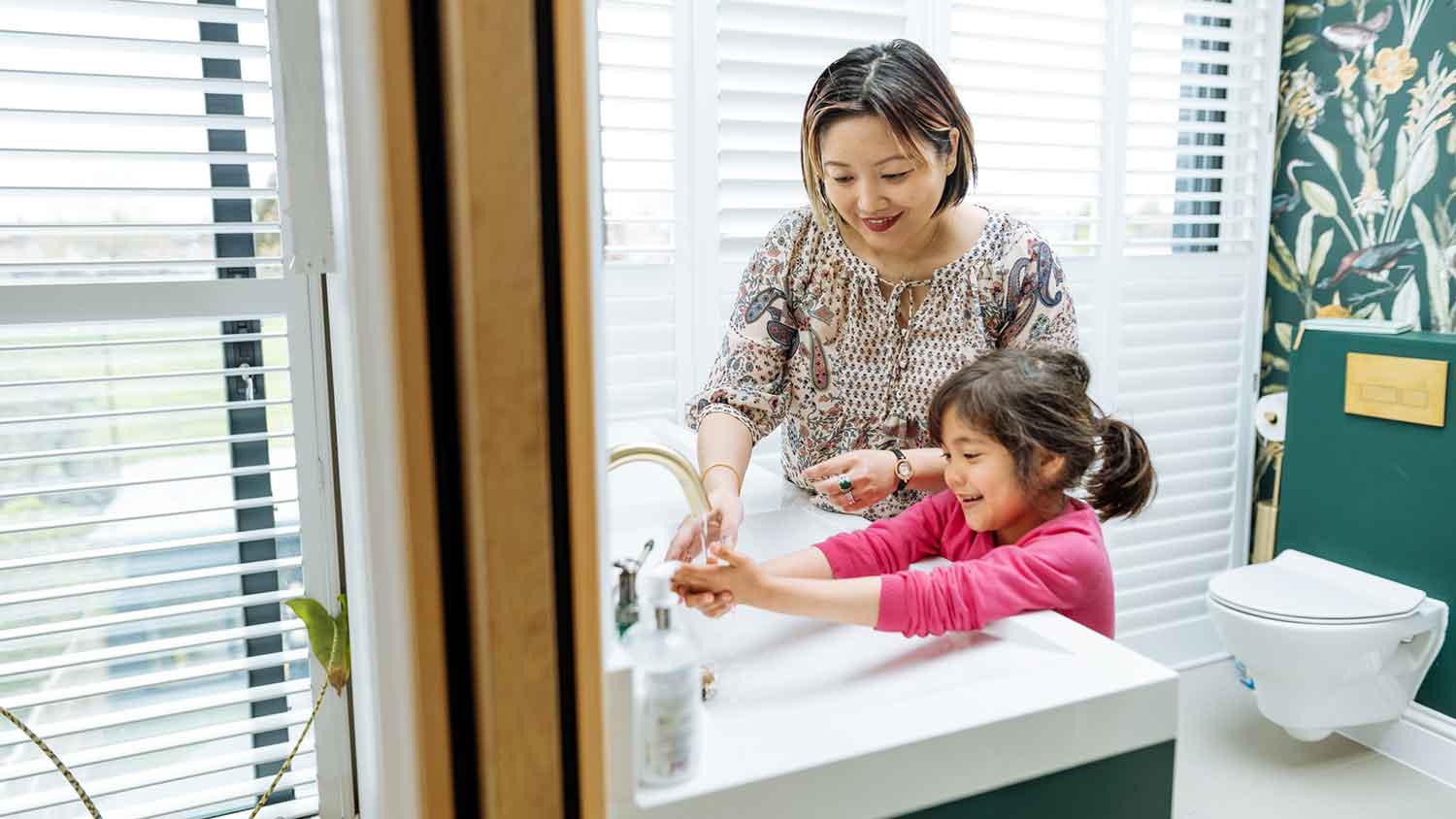 Mother helping daughter with morning bathroom routine