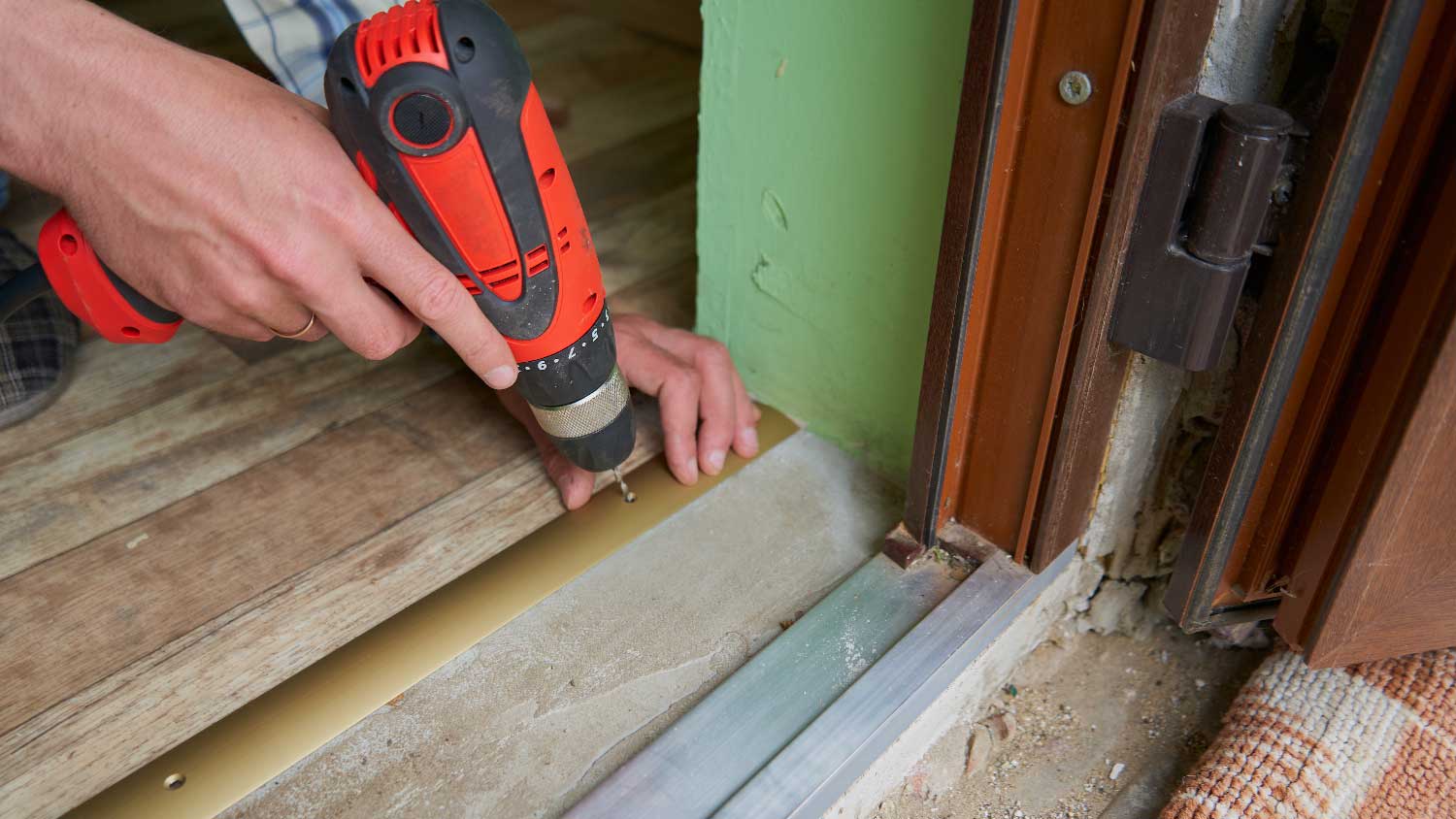 A person installing a door threshold