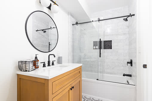 Bathroom with wooden cabinet and subway tile installed in the shower