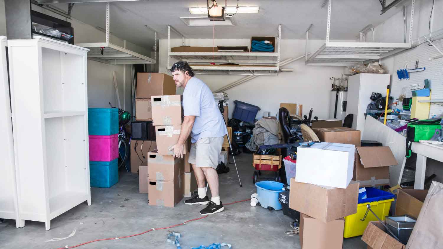 Man moving carboard boxes out of the garage