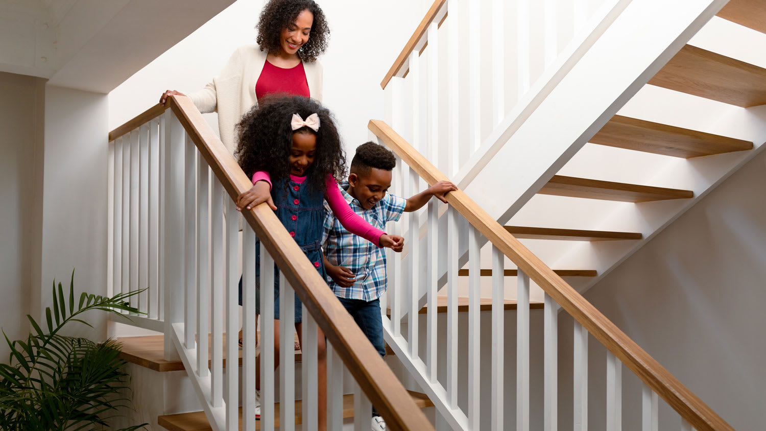 mother and kids walking down stairs in home
