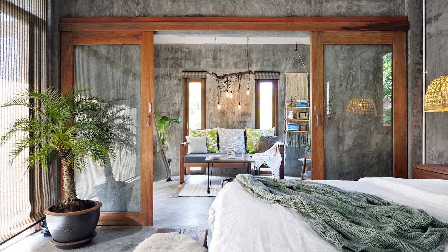 Bedroom interior with sliding glass doors and polished concrete walls