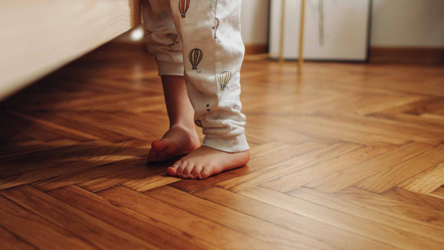 A child’s legs on a wooden floor