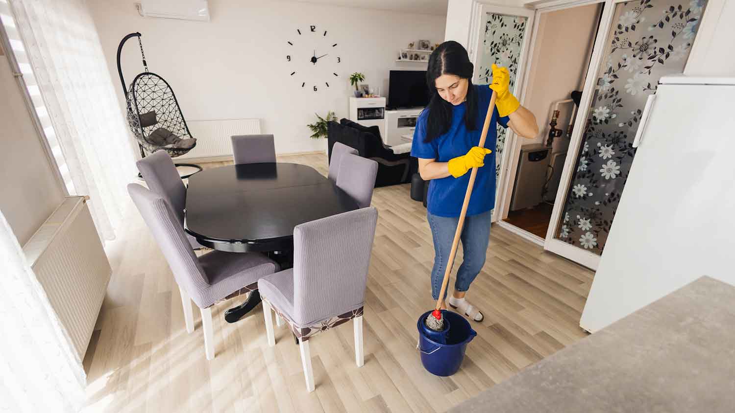 Professional cleaner mopping apartment floor