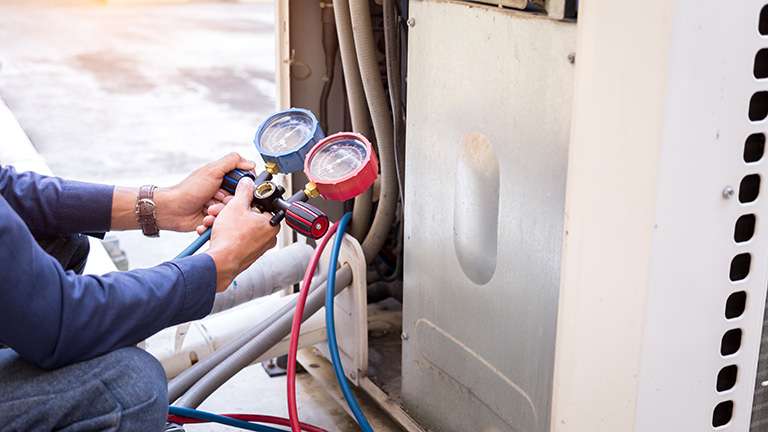 A technician checking air conditioning unit