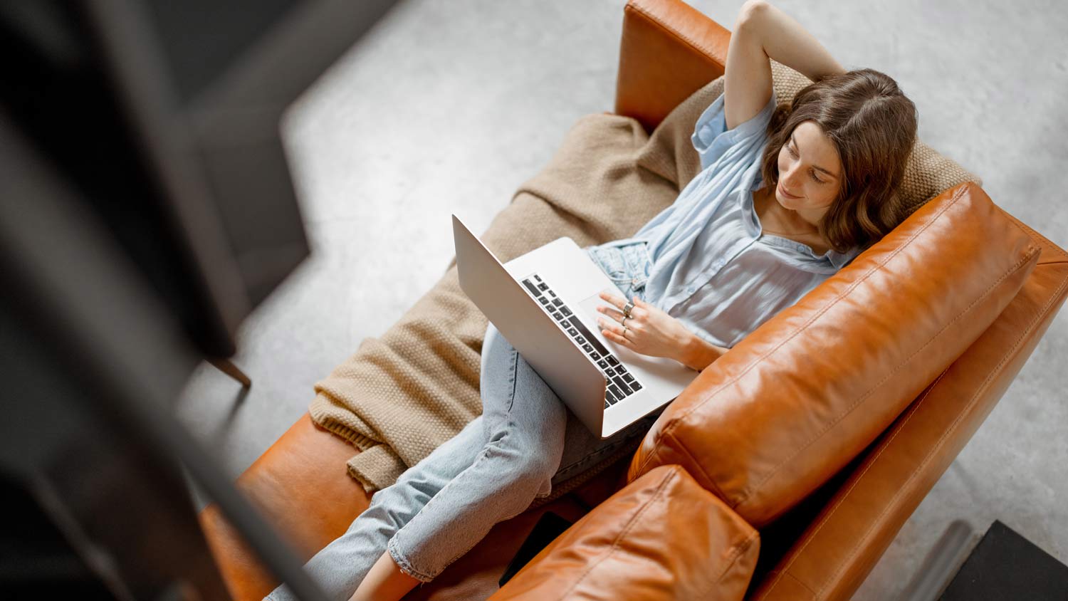 woman laying down on leather couch