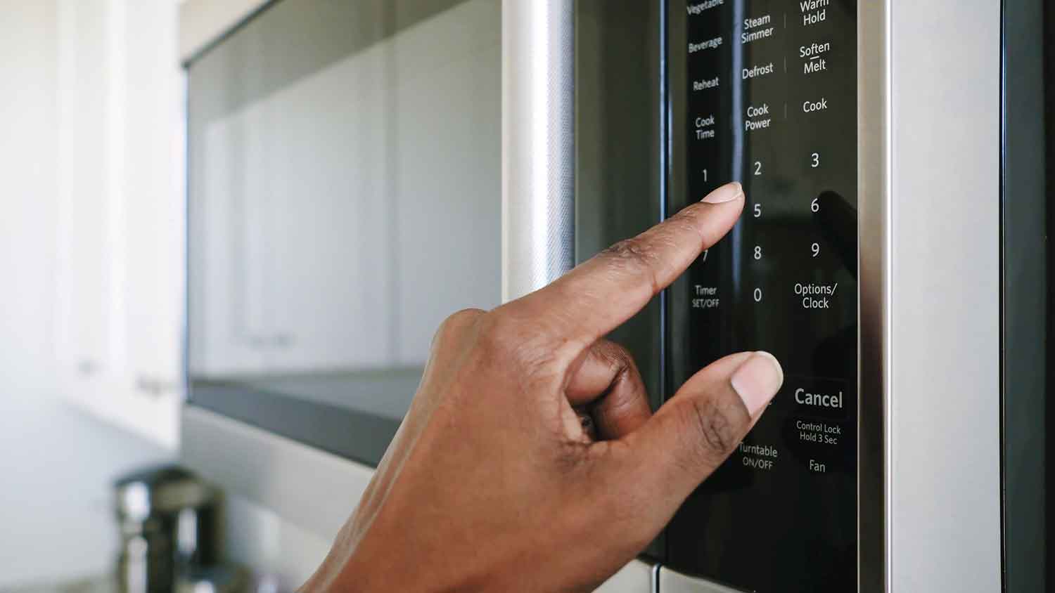Hand pressing microwave control panel